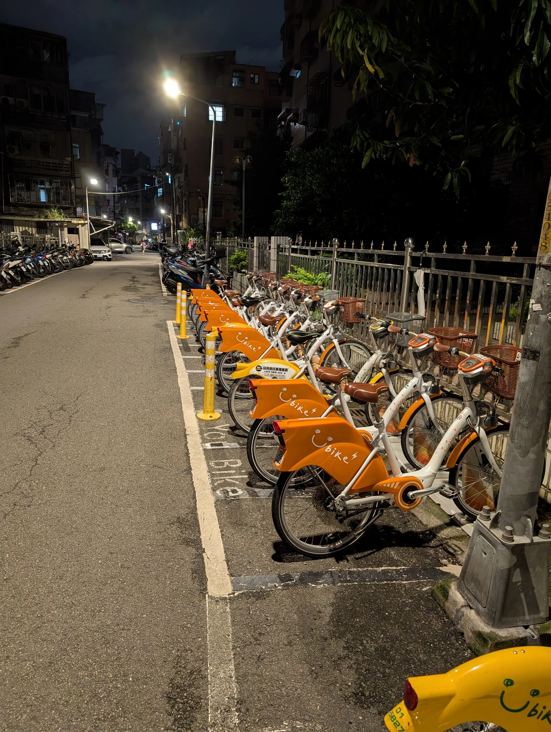 Image: A UBike station during night, with a lot or eBikes A UBike station during night, with a lot or eBikes